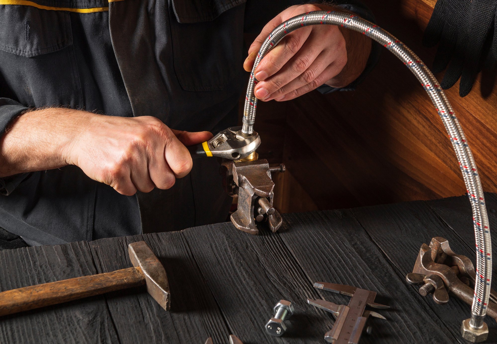 Plumber connects high pressure hose while repairing equipment. C